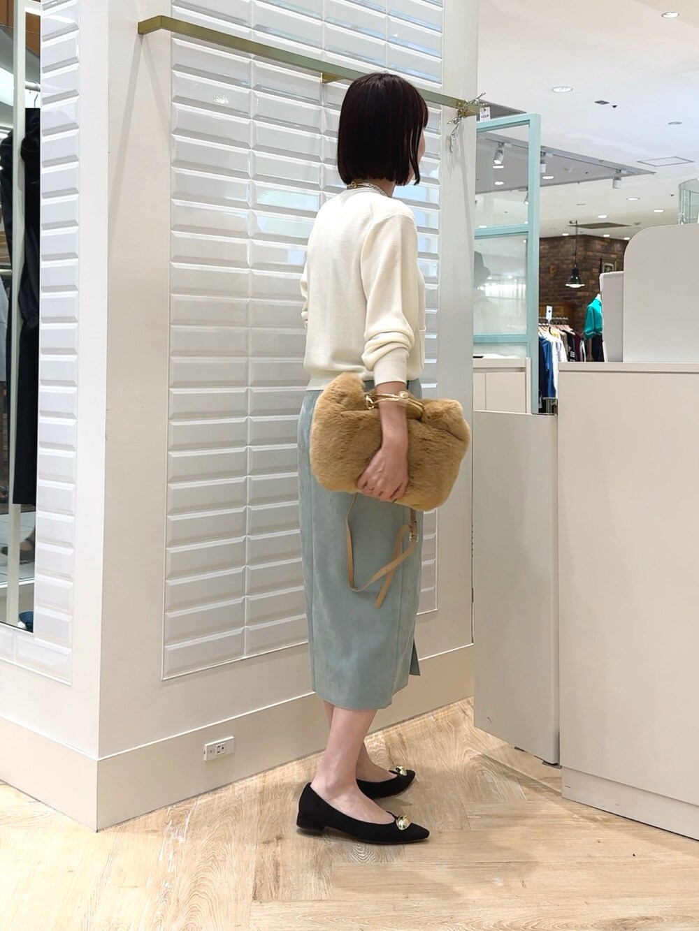 ホワイト系のカーディガン/ボレロ、ベージュ系のショルダーバッグ、グリーン系のスカートを着用したレディースの秋コーディネートの6枚目の写真