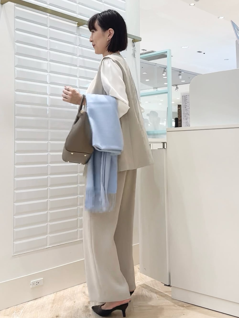 ブラウン系のショルダーバッグ、ベージュ系のその他パンツ、ベージュ系のベストを着用したレディースの秋コーディネートの5枚目の写真