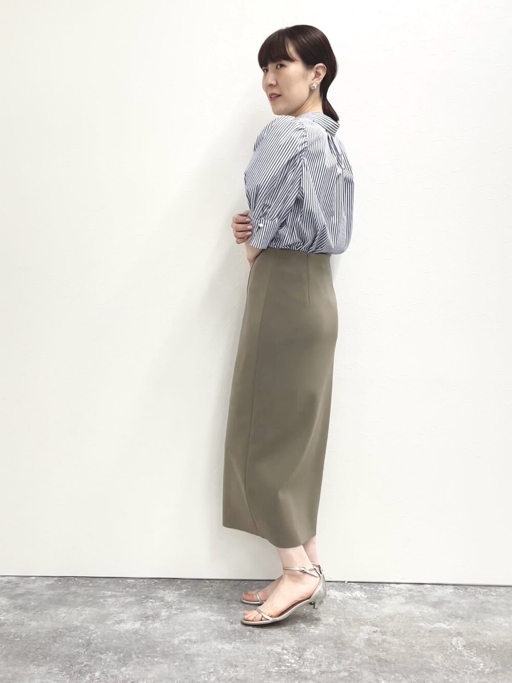 シルバー系のサンダル、グリーン系のスカート、ホワイト系のショルダーバッグを着用したレディースの春コーディネートの7枚目の写真
