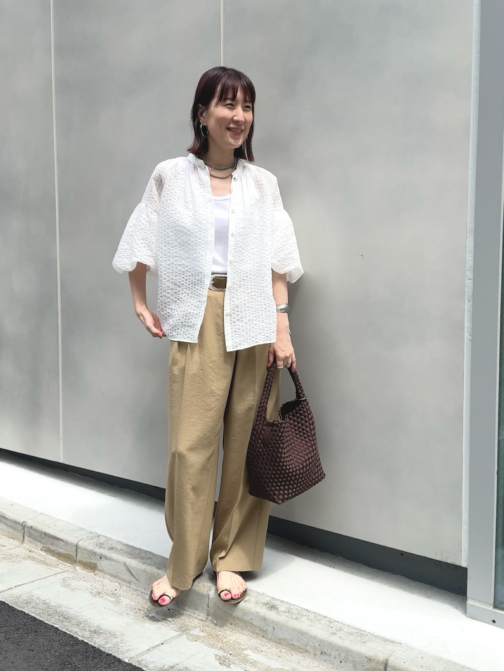 イエロー系のその他パンツ、ホワイト系のタンクトップ、ブラウン系のショルダーバッグを着用したレディースの夏コーディネートの6枚目の写真