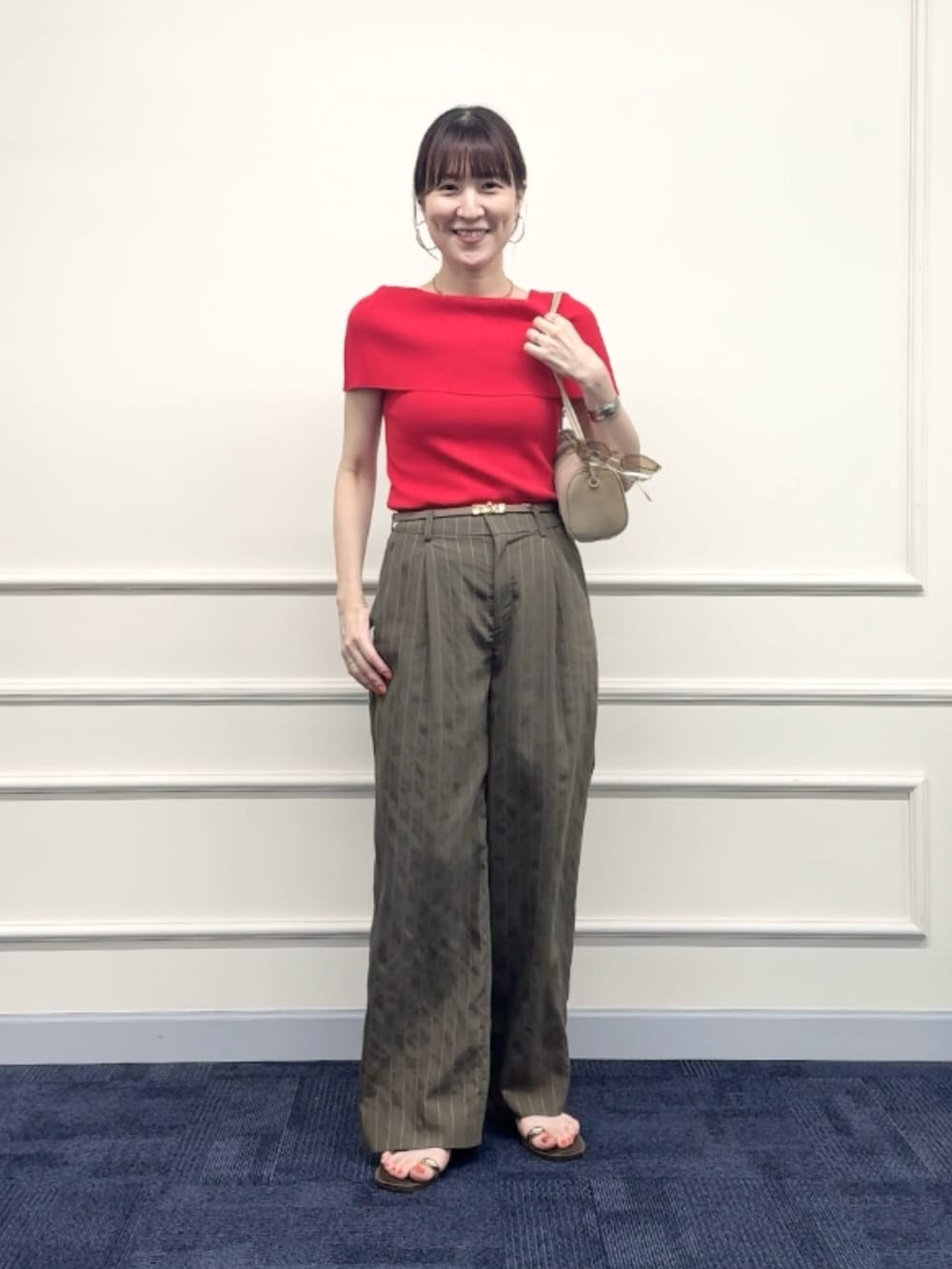 レッド系のニット/セーター、グリーン系のその他パンツ、ベージュ系のショルダーバッグを着用したレディースの夏コーディネートの6枚目の写真