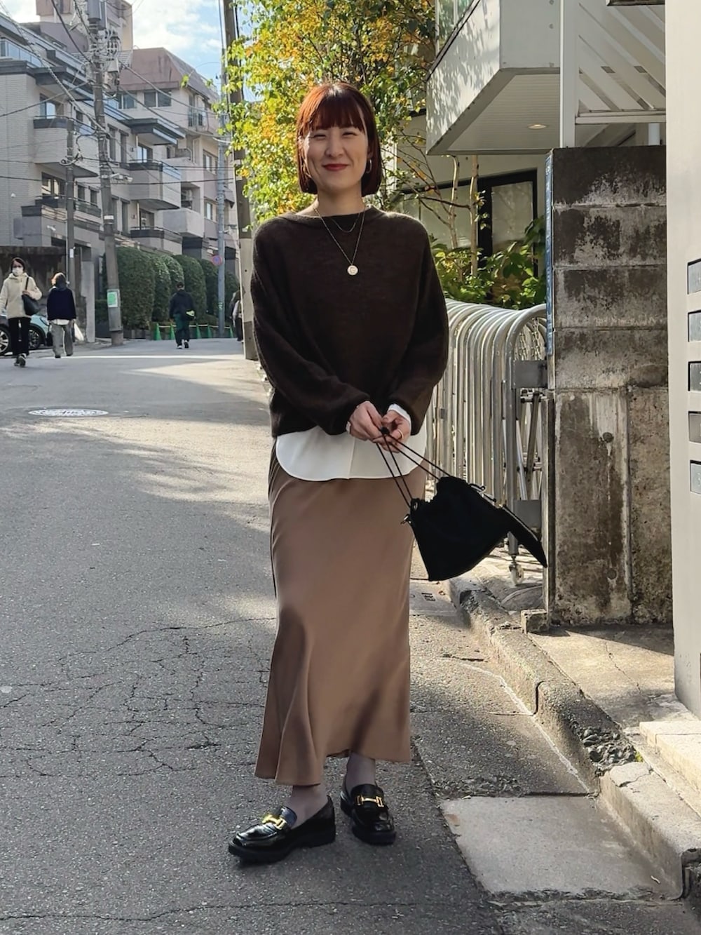 ホワイト系のシャツ/ブラウス、ブラウン系のニット/セーター、ブラック系のその他シューズを着用したレディースの冬コーディネートの5枚目の写真