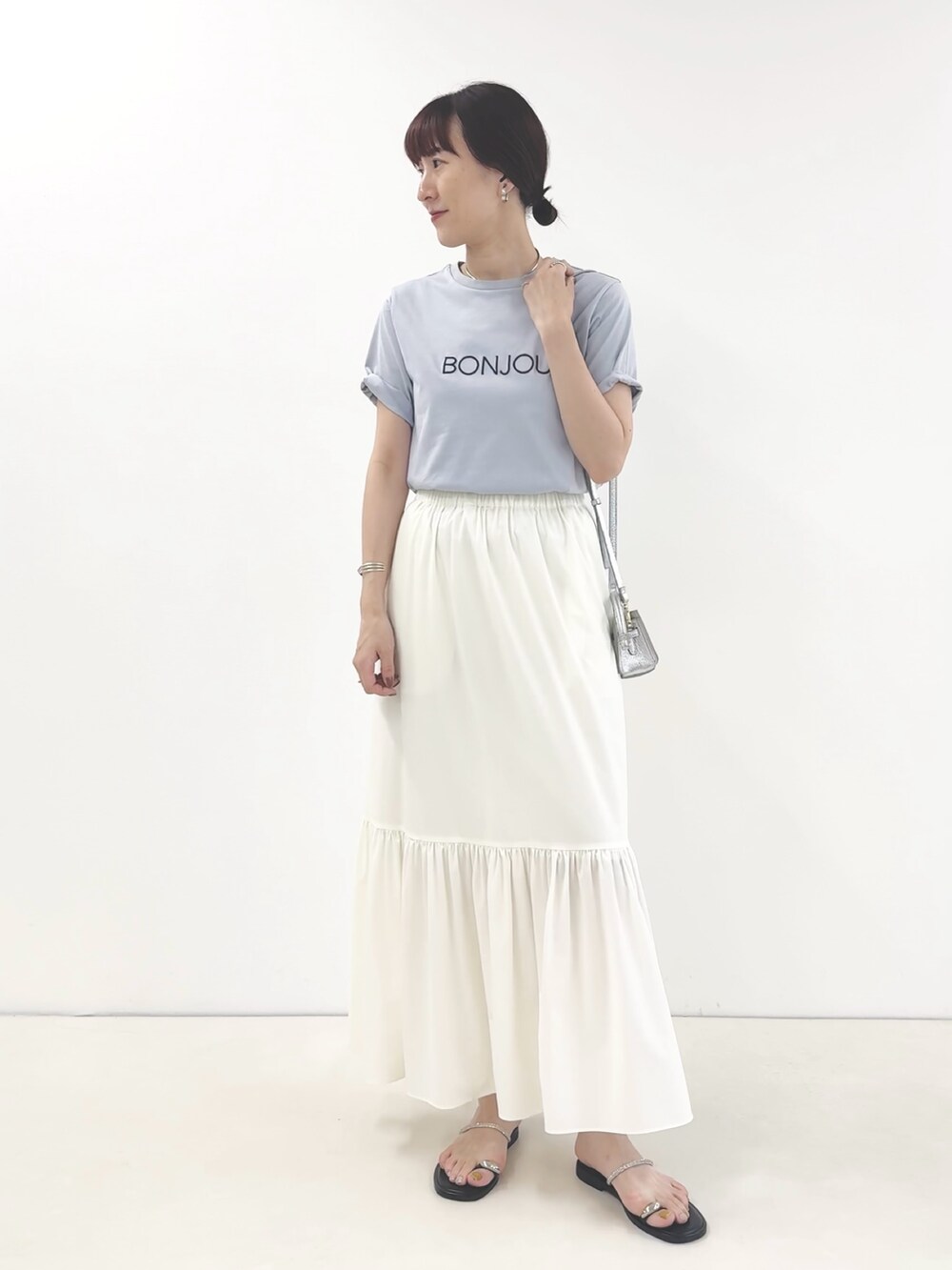 ホワイト系のスカート、シルバー系のサンダル、ブルー系のTシャツ/カットソーを着用したレディースの夏コーディネートの6枚目の写真