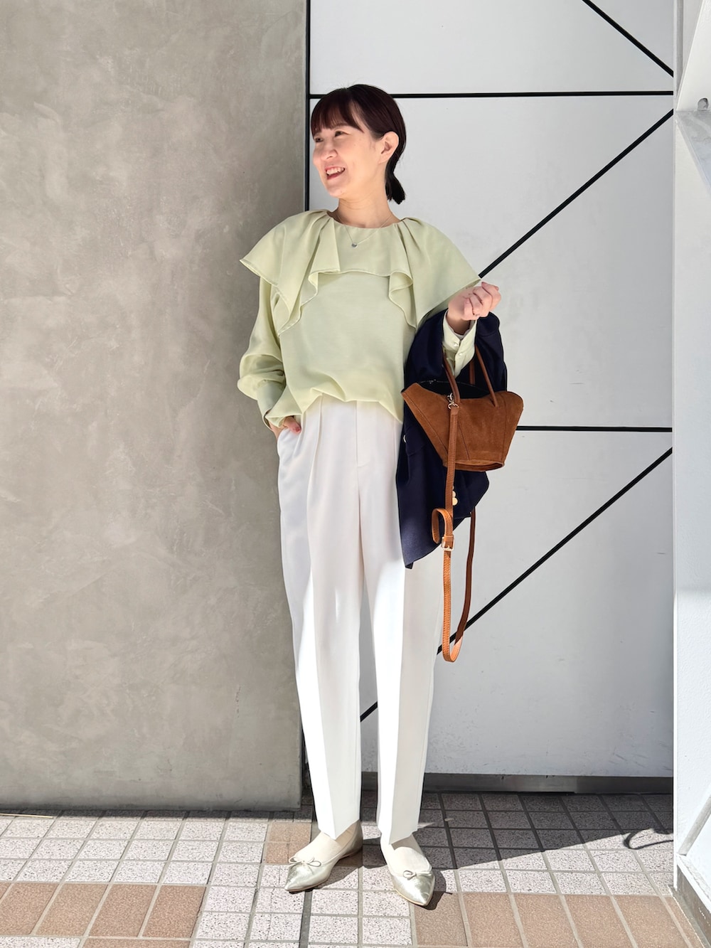 ホワイト系のその他パンツ、ブルー系のテーラードジャケット、イエロー系のトートバッグを着用したレディースの春コーディネートの7枚目の写真