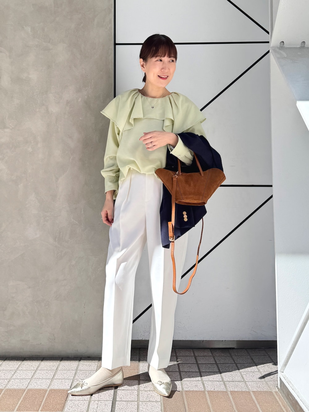 ホワイト系のその他パンツ、ブルー系のテーラードジャケット、イエロー系のトートバッグを着用したレディースの春コーディネートの4枚目の写真