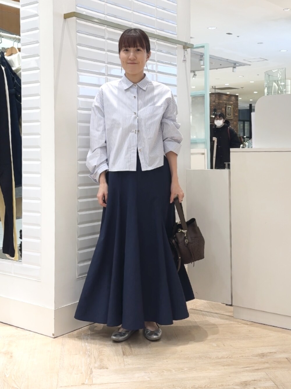 ブルー系のシャツ/ブラウス、ブルー系のスカート、ブラウン系のショルダーバッグを着用したレディースの春コーディネートの8枚目の写真