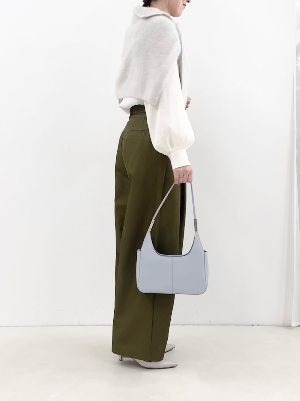 ブルー系のショルダーバッグ、グリーン系のチノパンツ、ホワイト系のシャツ/ブラウスを着用したレディースの秋コーディネートの4枚目の写真