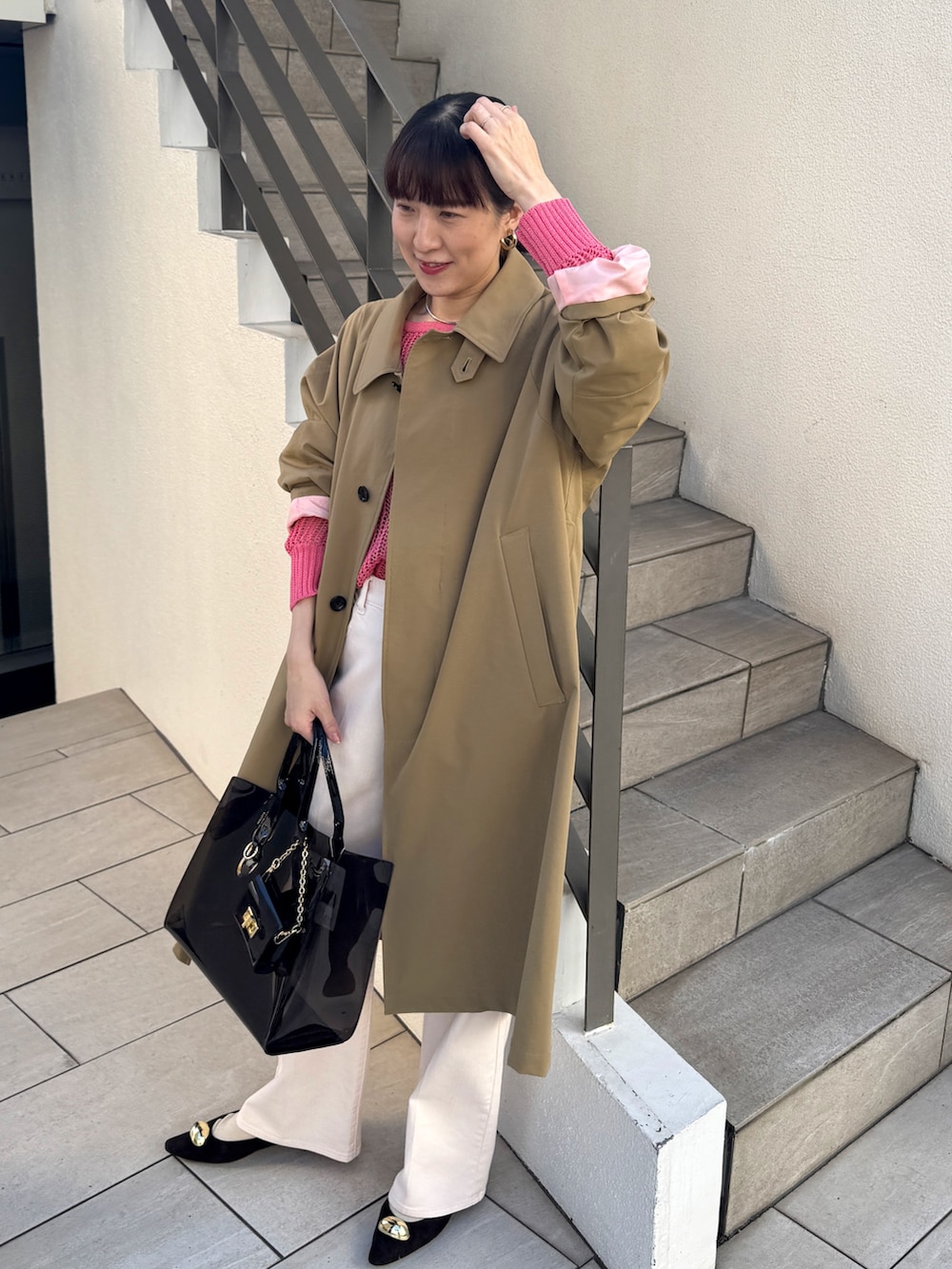 ピンク系のニット/セーター、ベージュ系のダッフルコート、ピンク系のデニムパンツを着用したレディースの冬コーディネートの5枚目の写真