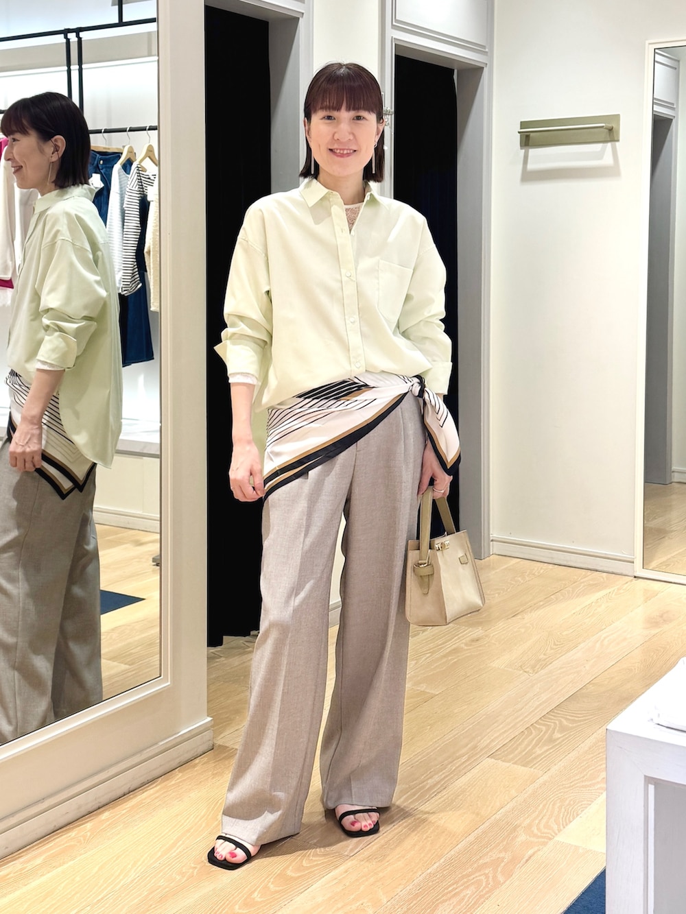 ベージュ系のその他パンツ、ベージュ系のトートバッグ、ホワイト系のシャツ/ブラウスを着用したレディースの春コーディネートの6枚目の写真