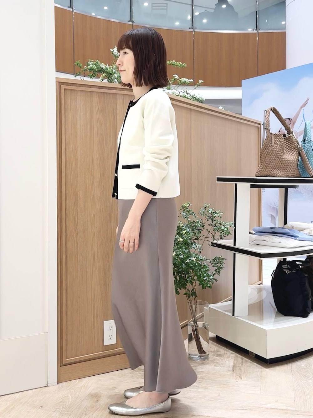 ベージュ系のトートバッグ、ホワイト系のシャツ/ブラウス、グリーン系のスカートを着用したレディースの春コーディネートの6枚目の写真