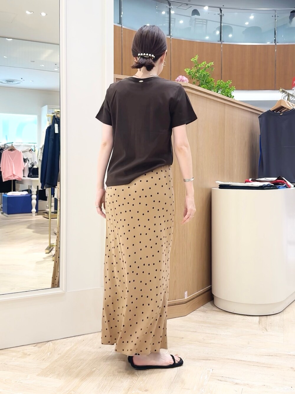 ブラウン系のスカート、ブラウン系のTシャツ/カットソー、シルバー系のチョーカーを着用したレディースの夏コーディネートの5枚目の写真