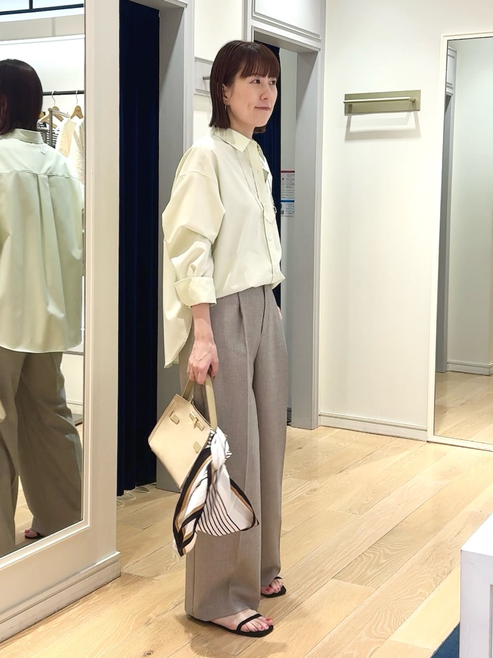 ベージュ系のその他パンツ、ベージュ系のトートバッグ、ホワイト系のシャツ/ブラウスを着用したレディースの春コーディネートの3枚目の写真