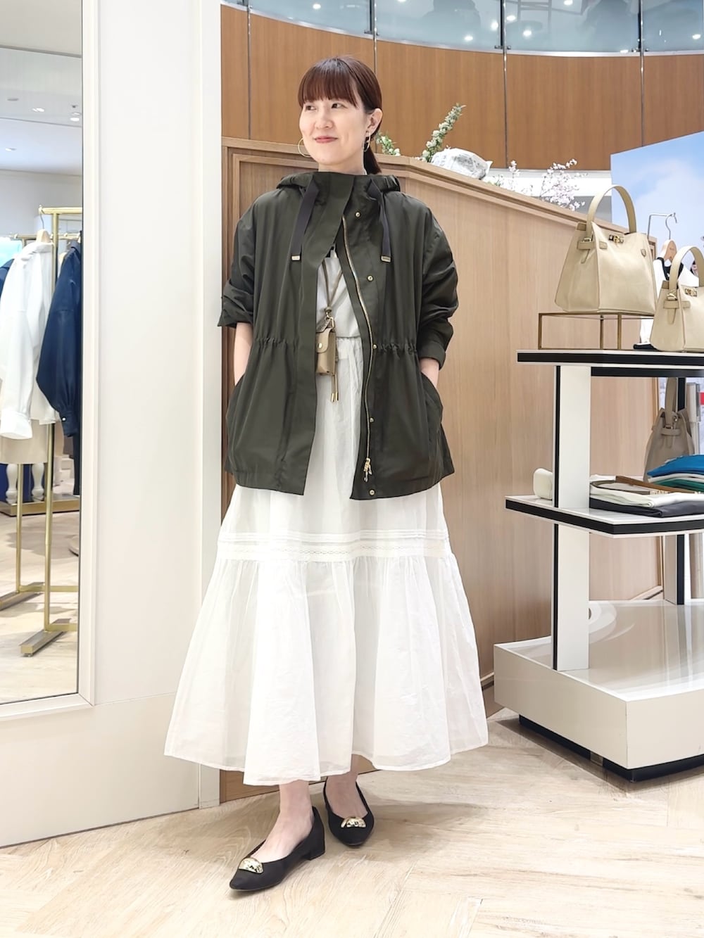 ブラウン系のショルダーバッグ、グレー系のブルゾン、ホワイト系のTシャツ/カットソーを着用したレディースの春コーディネートの2枚目の写真