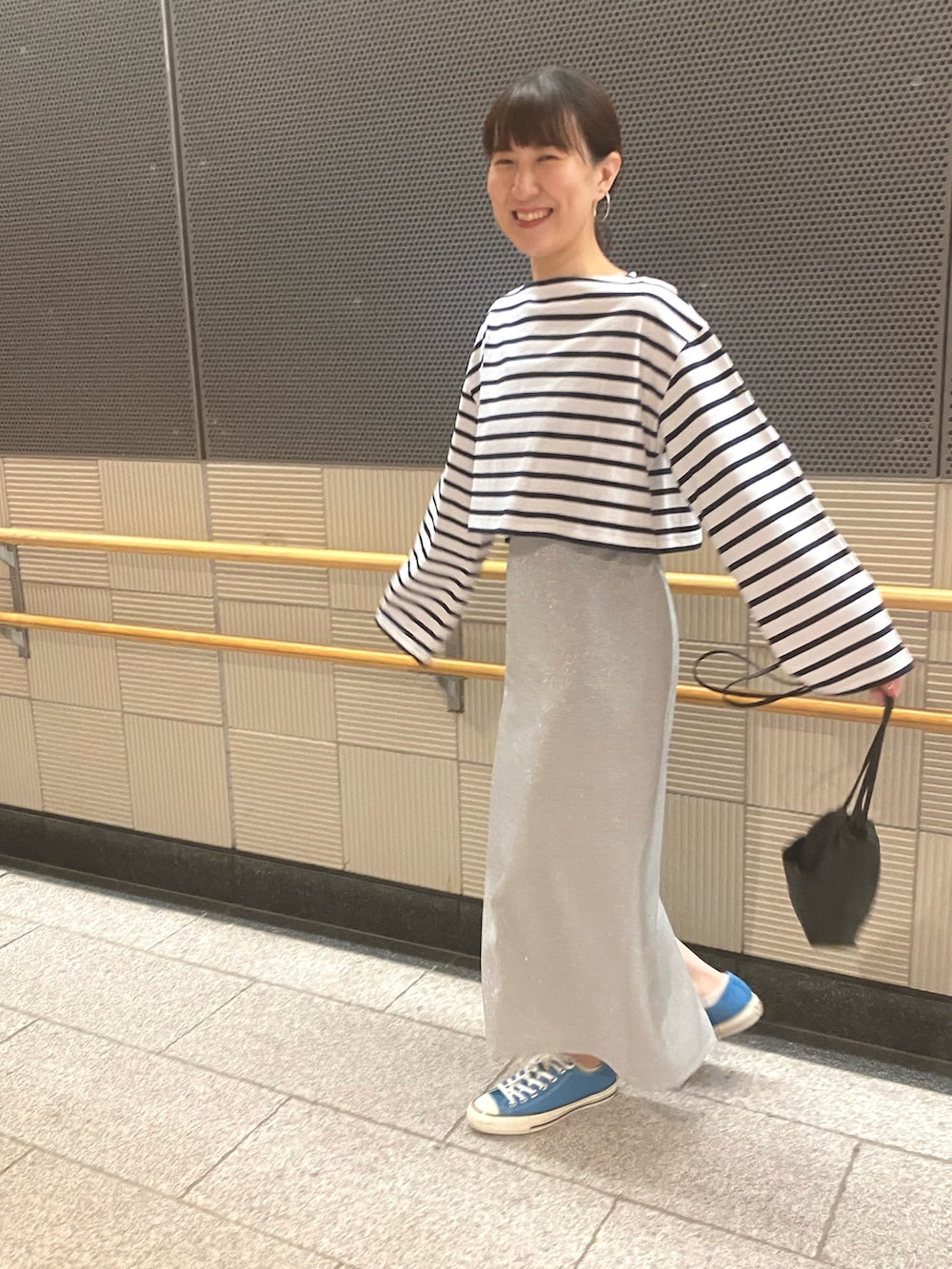 ピンク系のTシャツ/カットソー、シルバー系のスカート、ブルー系のスニーカーを着用したレディースの春コーディネートの6枚目の写真