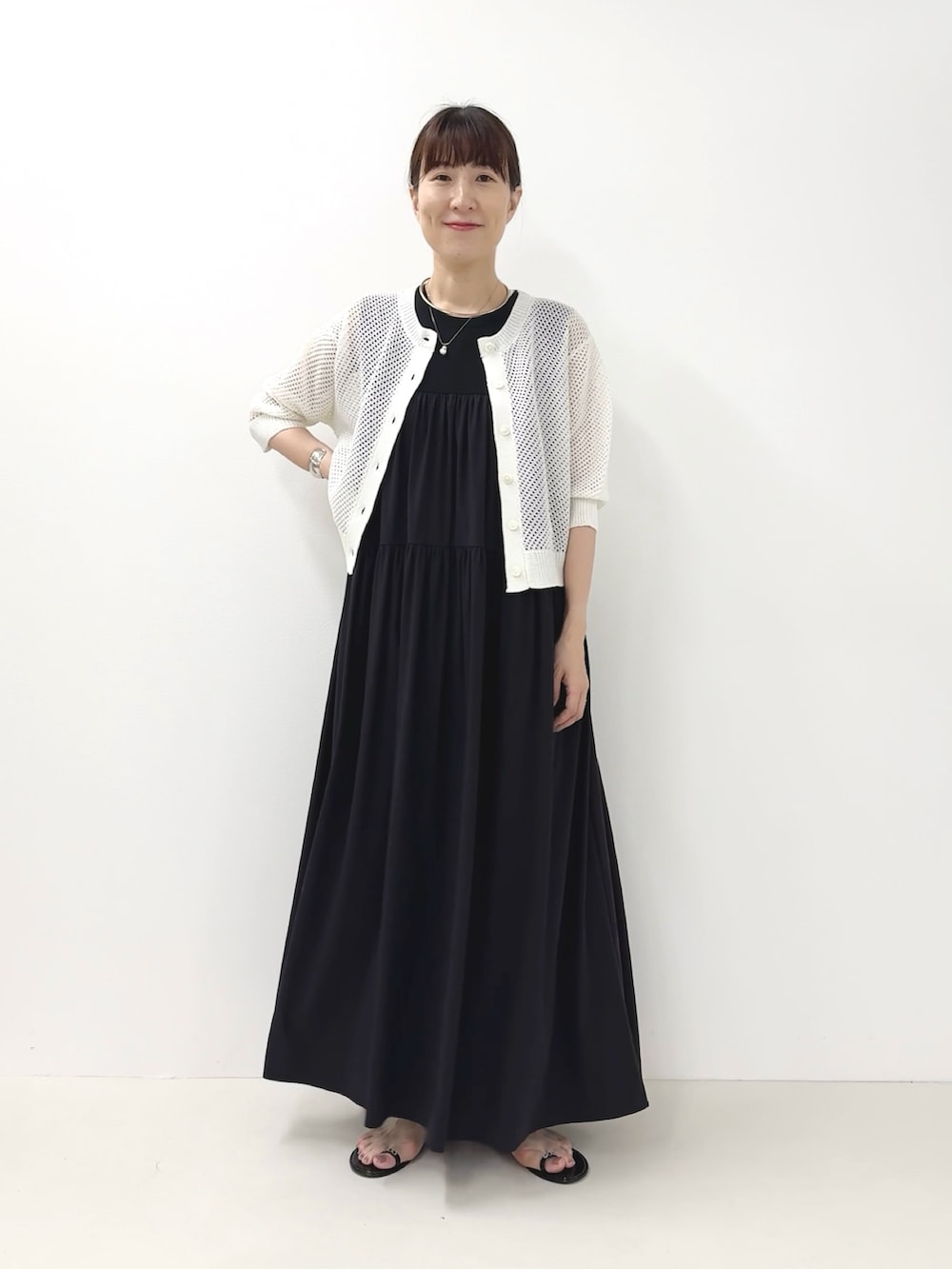 ブラック系のサンダル、ホワイト系のカーディガン/ボレロ、ブルー系のワンピースを着用したレディースの夏コーディネートの3枚目の写真