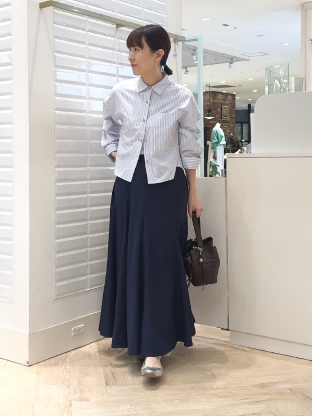 ブルー系のシャツ/ブラウス、ブルー系のスカート、ブラウン系のショルダーバッグを着用したレディースの春コーディネートの3枚目の写真