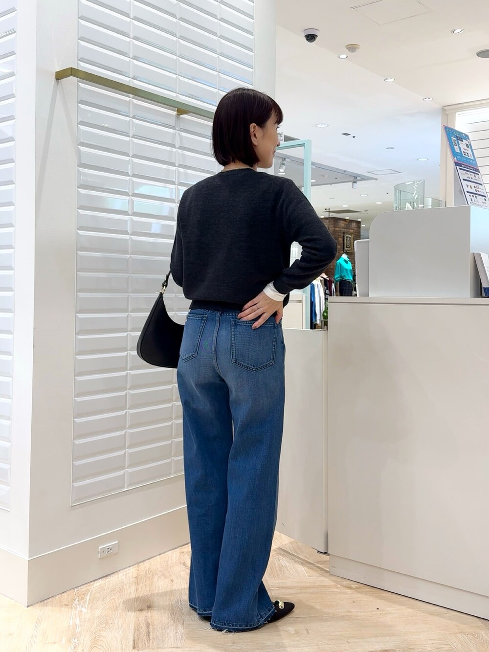 ブルー系のデニムパンツ、グレー系のカーディガン/ボレロ、ホワイト系のTシャツ/カットソーを着用したレディースの秋コーディネートの3枚目の写真