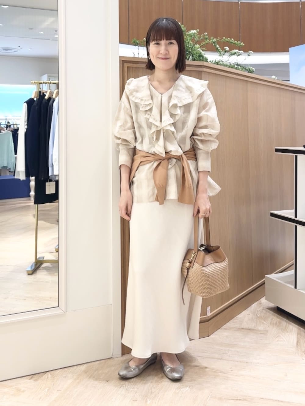 イエロー系のカーディガン/ボレロ、ホワイト系のシャツ/ブラウス、ベージュ系のショルダーバッグを着用したレディースの春コーディネートの4枚目の写真