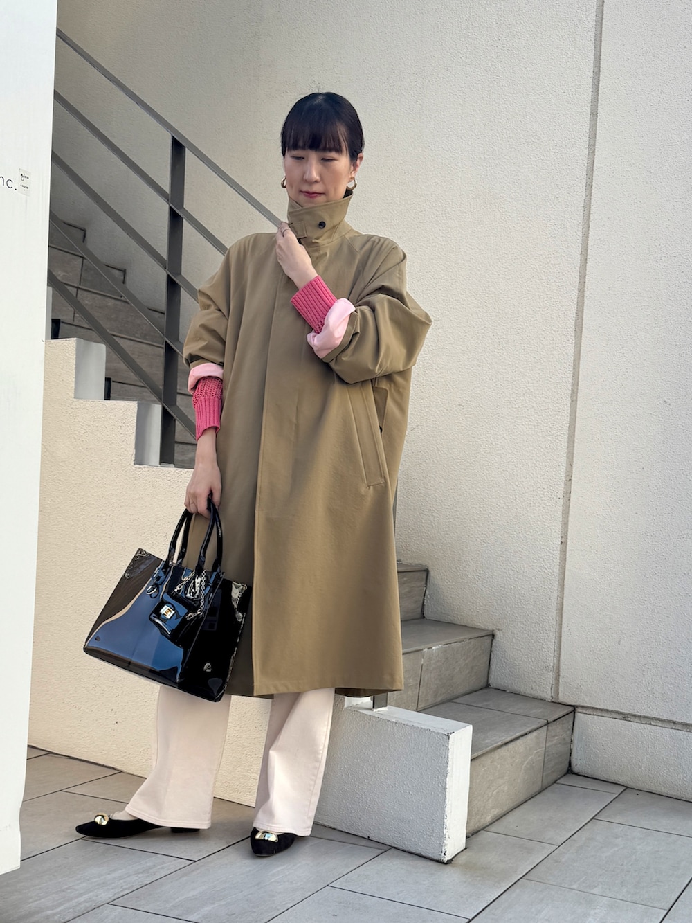 ピンク系のニット/セーター、ベージュ系のダッフルコート、ピンク系のデニムパンツを着用したレディースの冬コーディネートの4枚目の写真