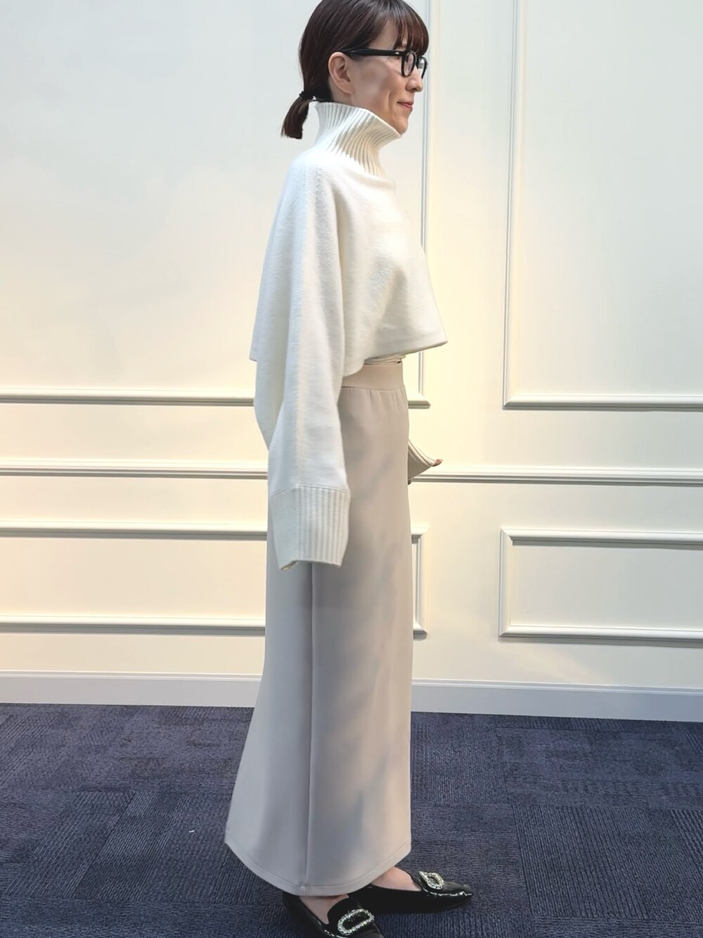 ベージュ系のスカート、ホワイト系のニット/セーターを着用したレディースの秋コーディネートの4枚目の写真