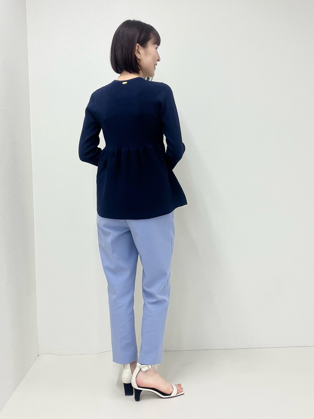 ブルー系のその他パンツ、ホワイト系のショルダーバッグ、ブルー系のニット/セーターを着用したレディースの冬コーディネートの6枚目の写真