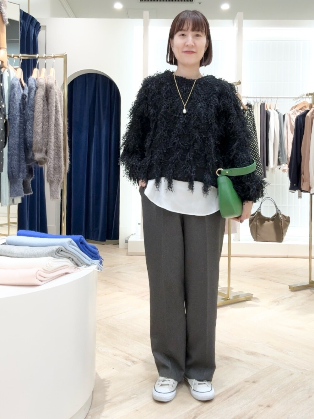 グレー系のその他パンツ、ホワイト系のシャツ/ブラウス、ブラック系のニット/セーターを着用したレディースの秋コーディネートの2枚目の写真