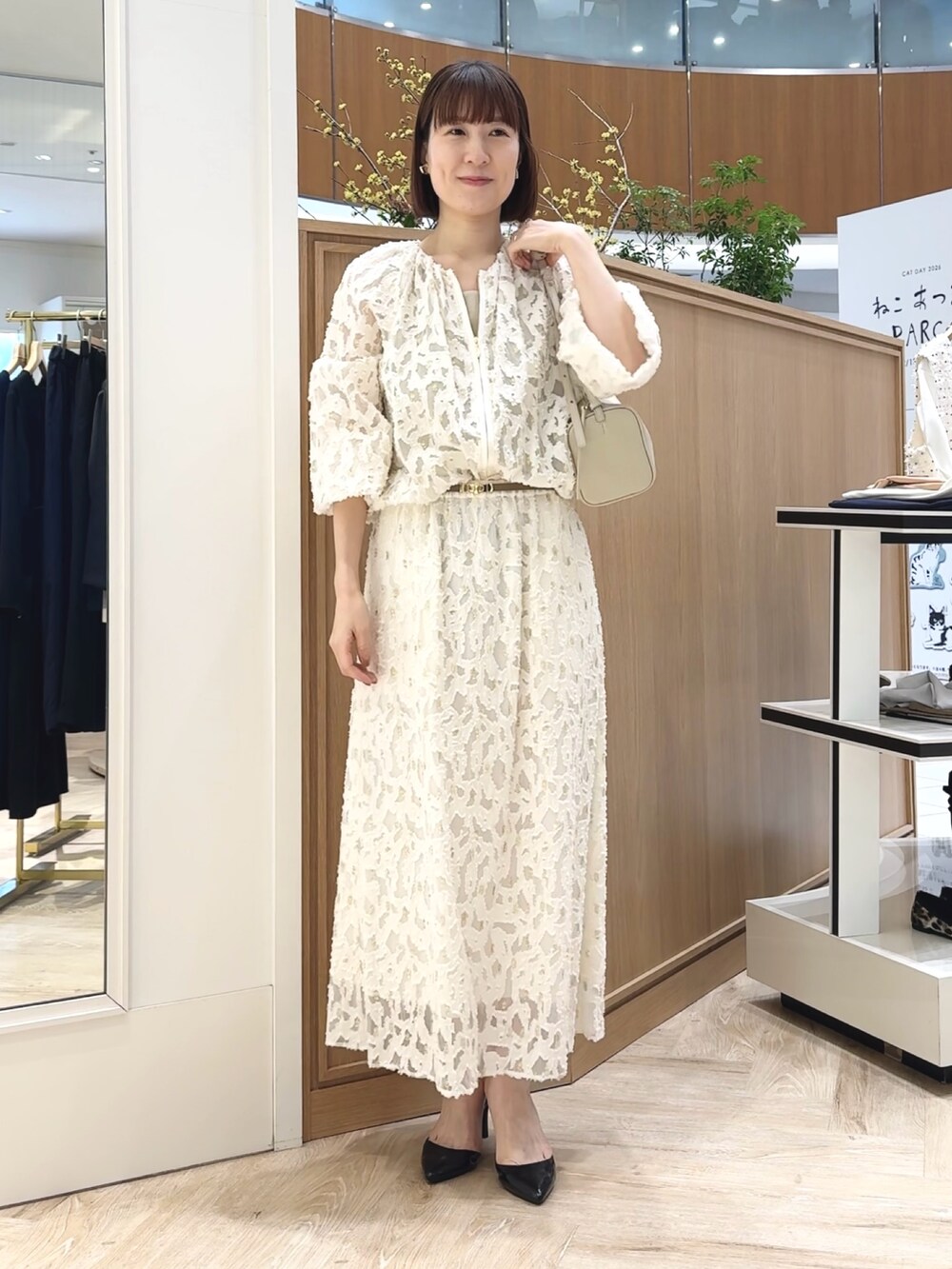 ホワイト系のショルダーバッグ、ゴールド系のタンクトップ、ホワイト系のブルゾンを着用したレディースの冬コーディネートの9枚目の写真