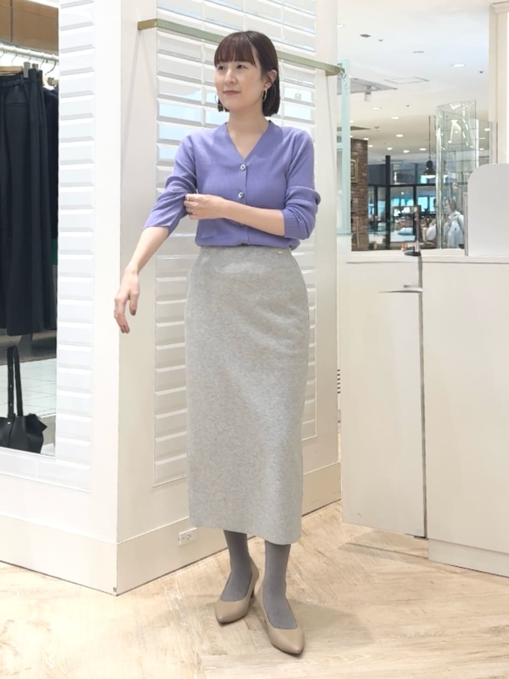 グレー系のスカート、パープル系のカーディガン/ボレロを着用したレディースの秋コーディネートの3枚目の写真