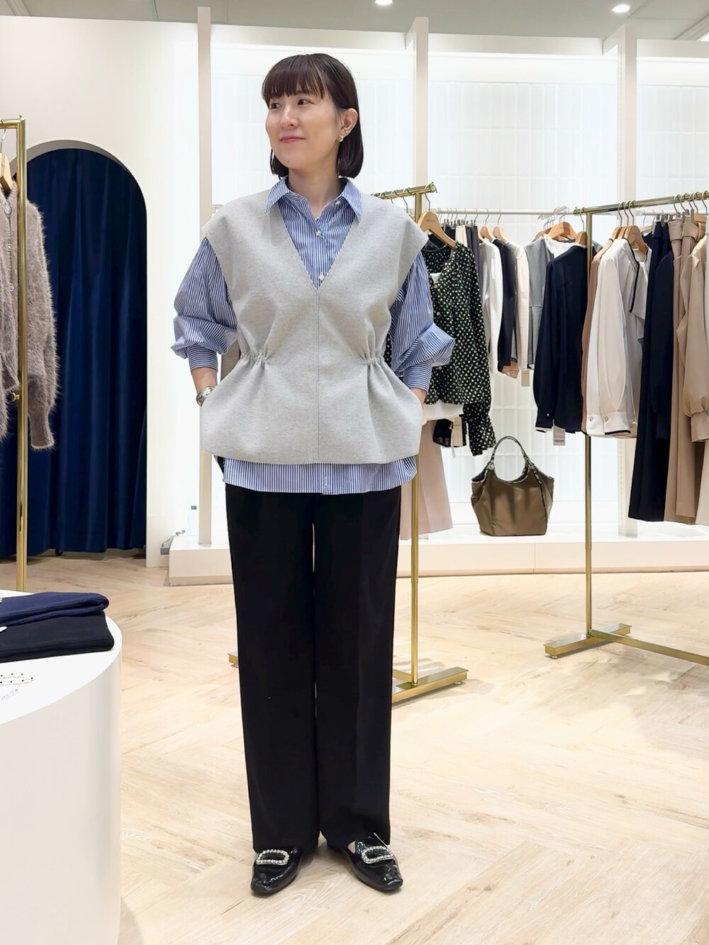 ブルー系のその他パンツ、グレー系のベスト、ブルー系のシャツ/ブラウスを着用したレディースの秋コーディネートの4枚目の写真