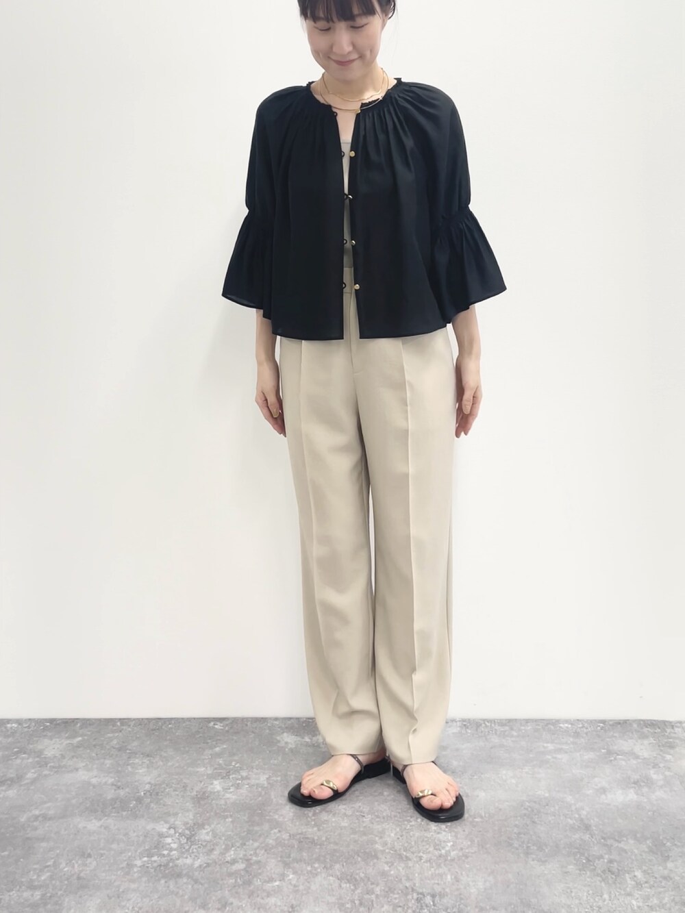 ベージュ系のその他パンツ、ベージュ系のニット/セーター、ブラック系のシャツ/ブラウスを着用したレディースの春コーディネートの5枚目の写真