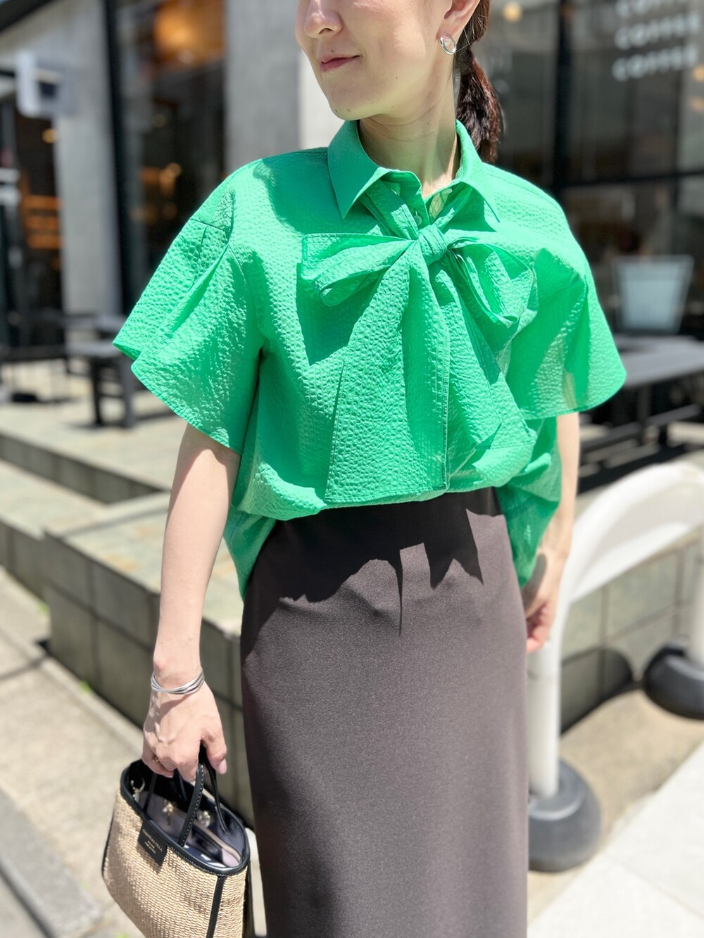 ブラック系のトートバッグ、グレー系のスカート、ブラック系のサンダルを着用したレディースの夏コーディネートの4枚目の写真