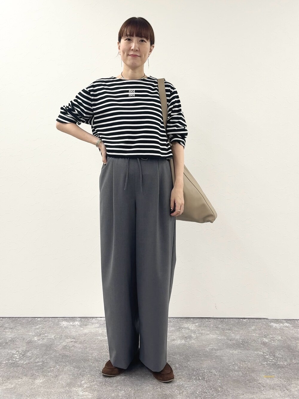 ブラック系のTシャツ/カットソー、ベージュ系のショルダーバッグ、グレー系のその他パンツを着用したレディースの秋コーディネートの6枚目の写真