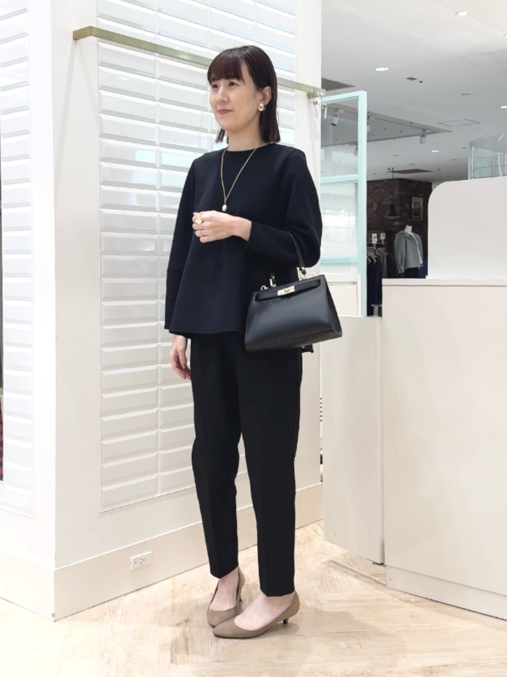 ブラック系のショルダーバッグ、ブラック系のその他パンツ、ブラック系のTシャツ/カットソーを着用したレディースの冬コーディネートの8枚目の写真