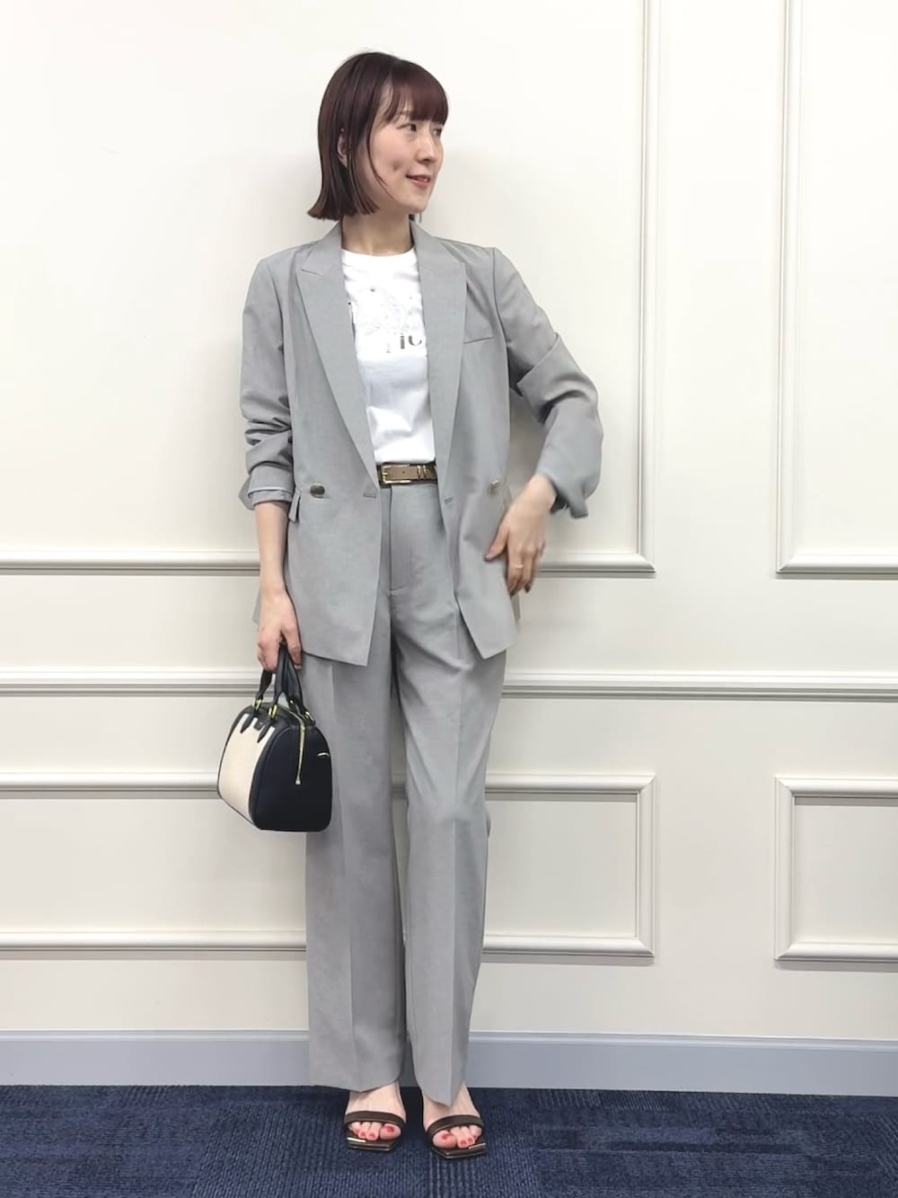 ブラック系のボストンバッグ、グレー系のその他パンツ、ホワイト系のTシャツ/カットソーを着用したレディースの春コーディネートの3枚目の写真