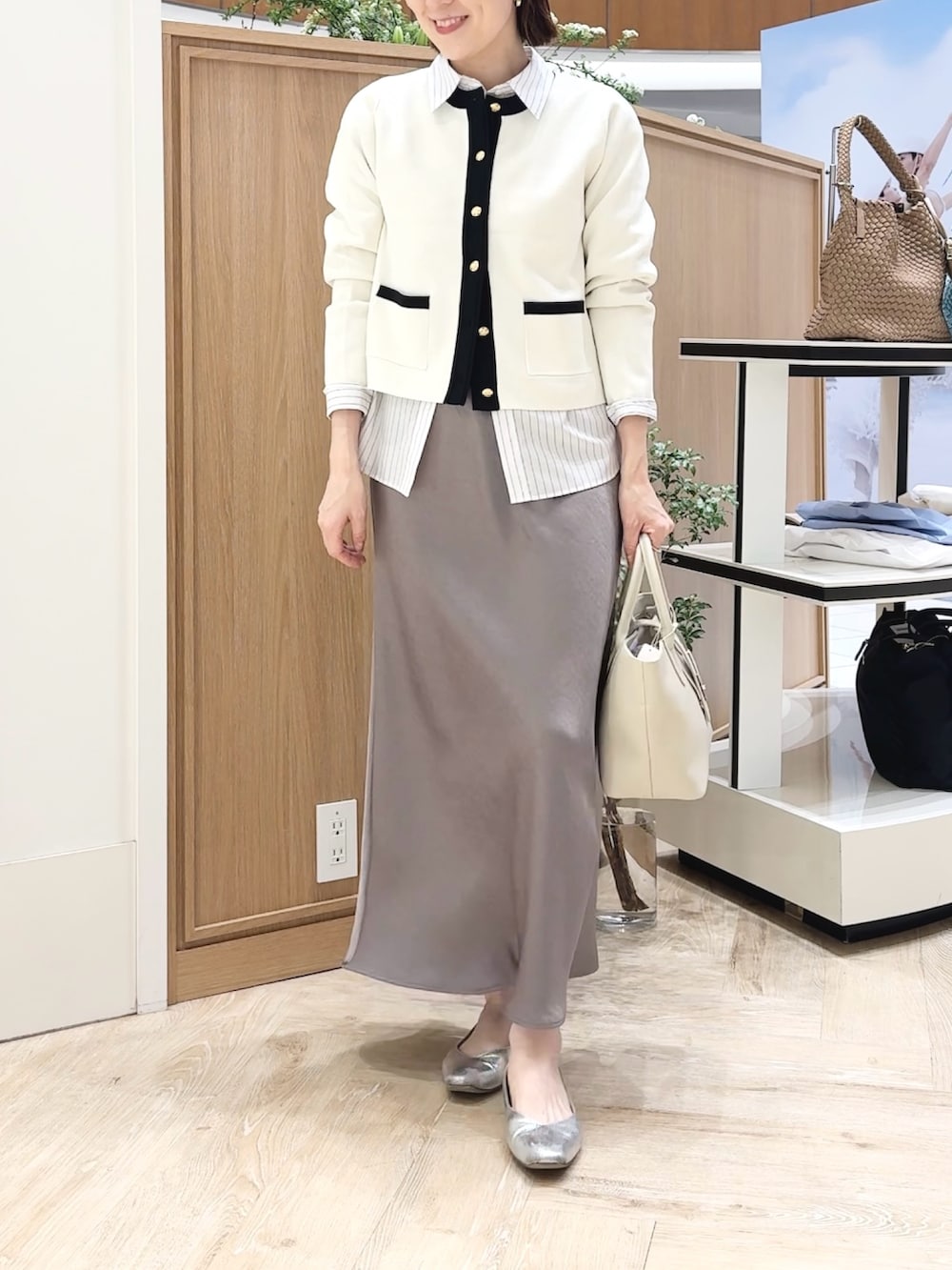 ベージュ系のトートバッグ、ホワイト系のシャツ/ブラウス、グリーン系のスカートを着用したレディースの春コーディネートの9枚目の写真