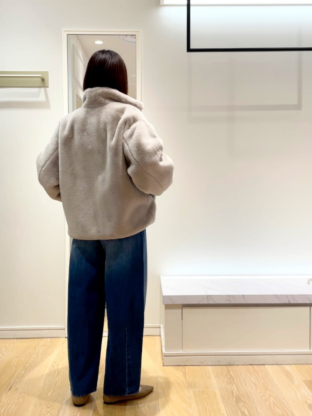 ブルー系のデニムパンツ、グレー系のブルゾン、ブラック系のニット/セーターを着用したレディースの秋コーディネートの9枚目の写真