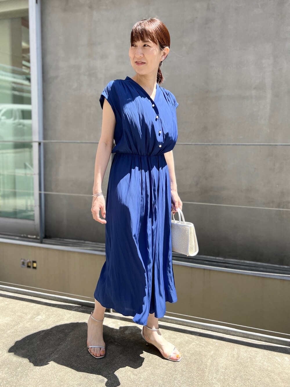 ホワイト系のトートバッグ、ブルー系のワンピース、ホワイト系のサンダルを着用したレディースの春コーディネートの9枚目の写真