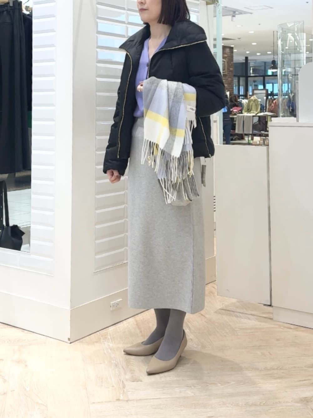 ブラック系のダウンジャケット/コート、パープル系のカーディガン/ボレロ、グレー系のスカートを着用したレディースの秋コーディネートの6枚目の写真