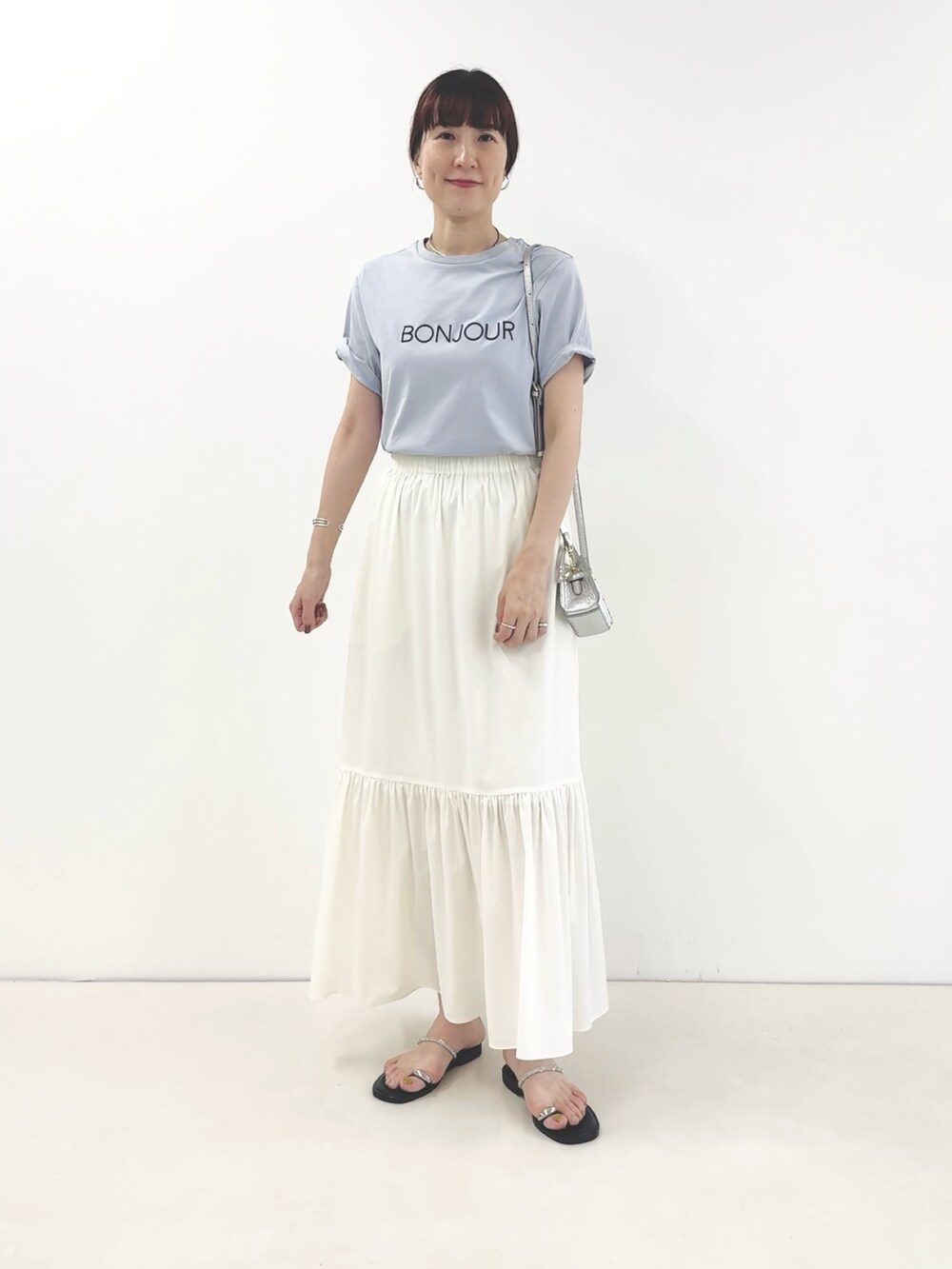 ホワイト系のスカート、シルバー系のサンダル、ブルー系のTシャツ/カットソーを着用したレディースの夏コーディネートの5枚目の写真