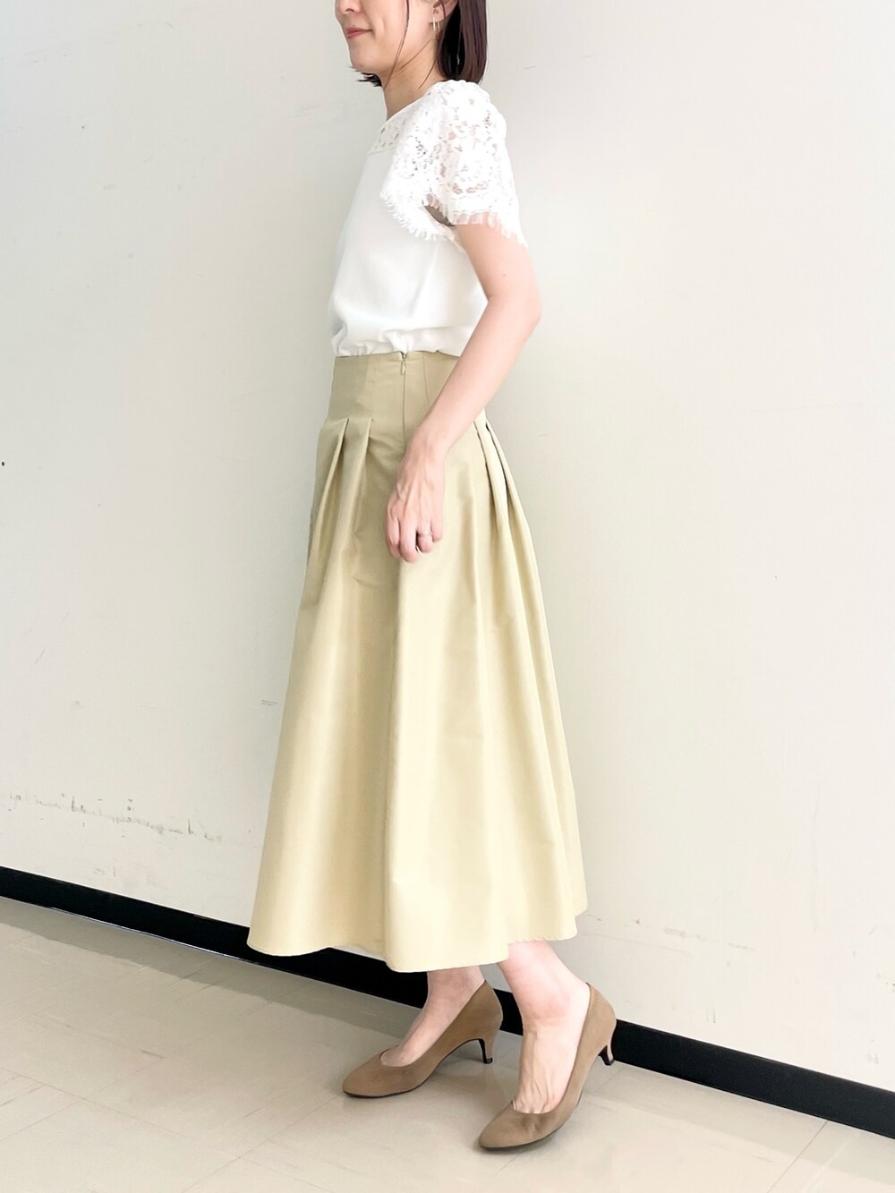 ベージュ系のスカート、ホワイト系のノーカラージャケット、ホワイト系のニット/セーターを着用したレディースの春コーディネートの4枚目の写真