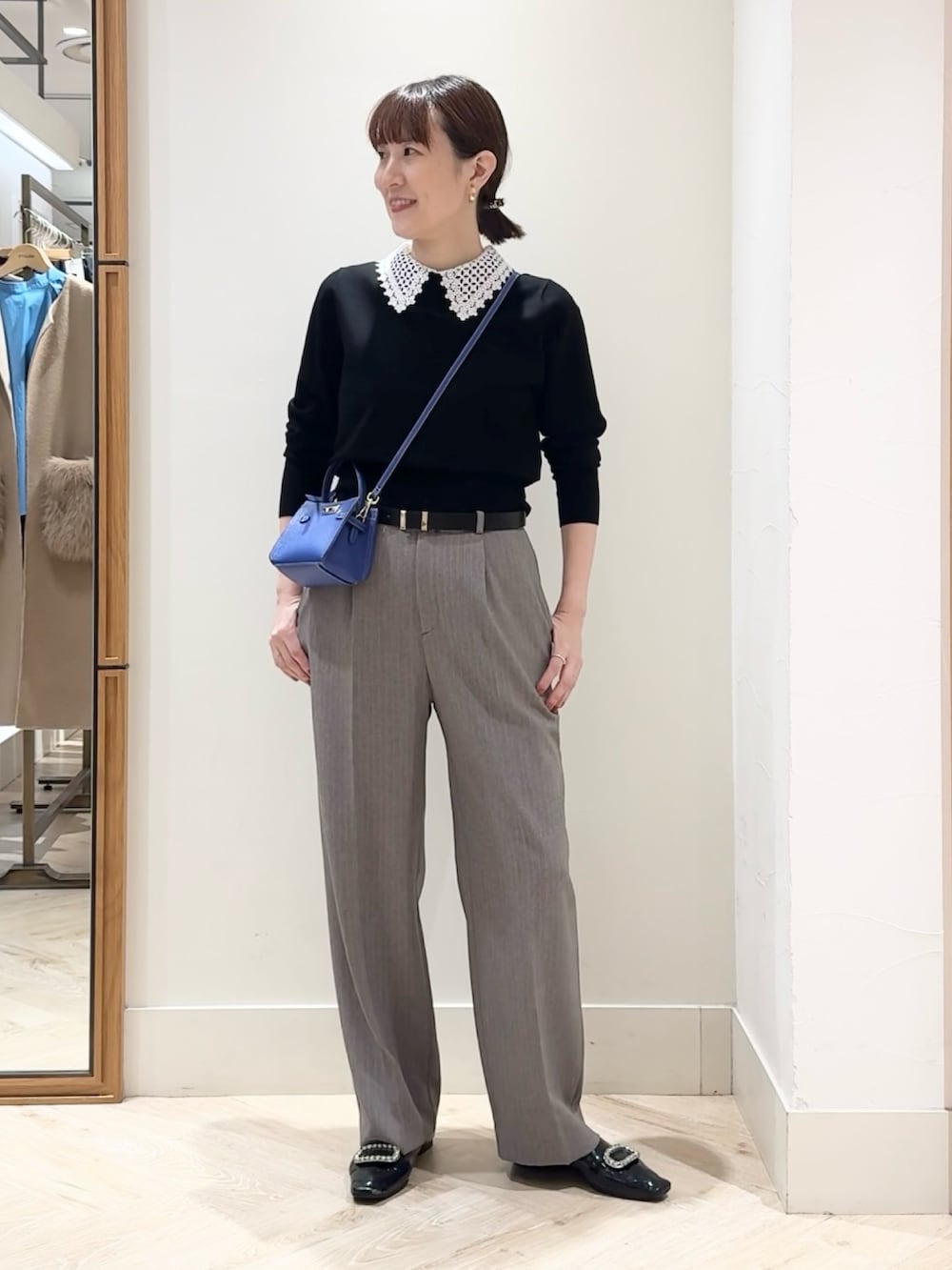 ブラウン系のその他パンツ、ブルー系のショルダーバッグ、ブラック系のニット/セーターを着用したレディースの秋コーディネートの2枚目の写真