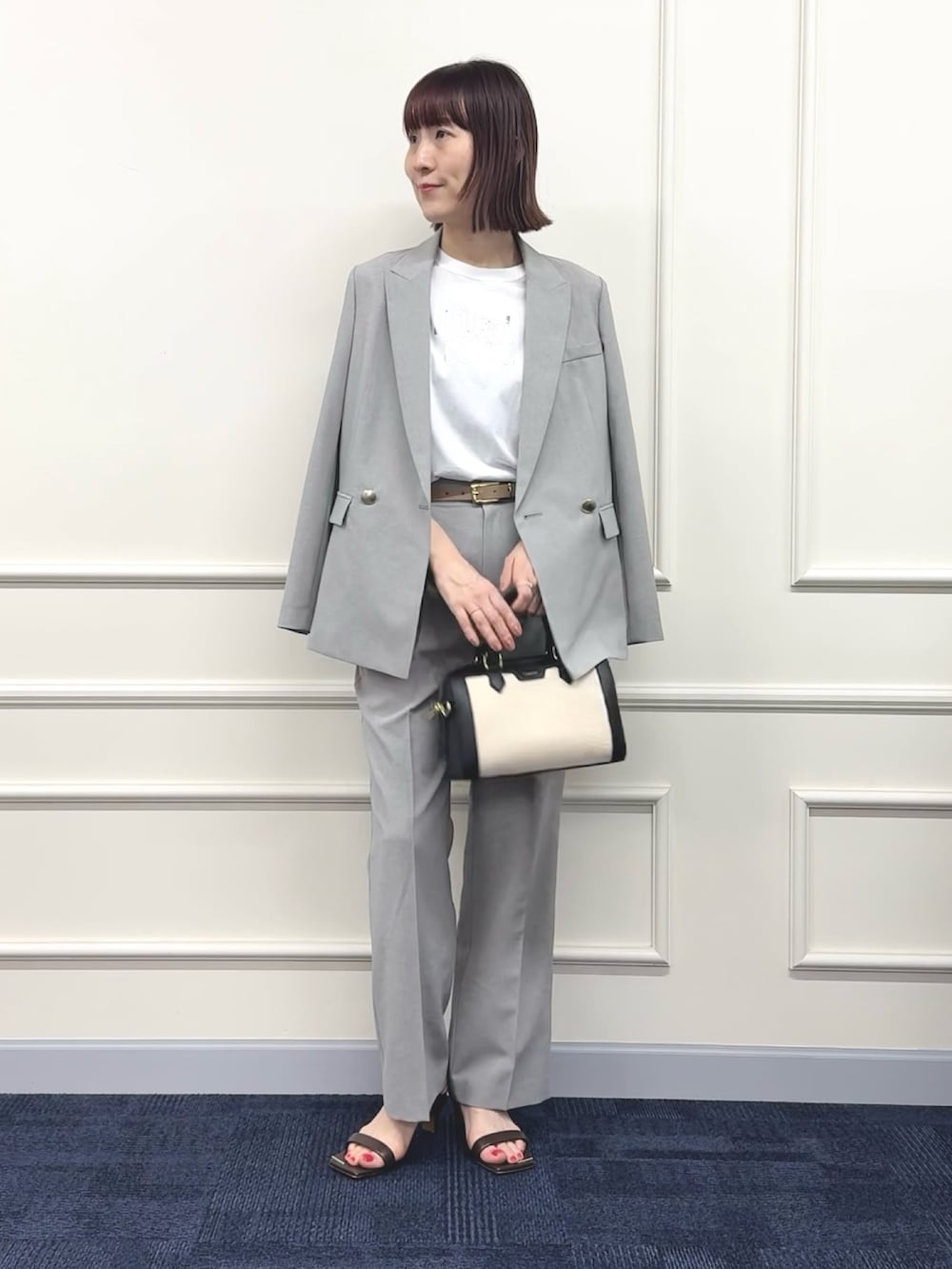 ブラック系のボストンバッグ、グレー系のその他パンツ、ホワイト系のTシャツ/カットソーを着用したレディースの春コーディネートの2枚目の写真