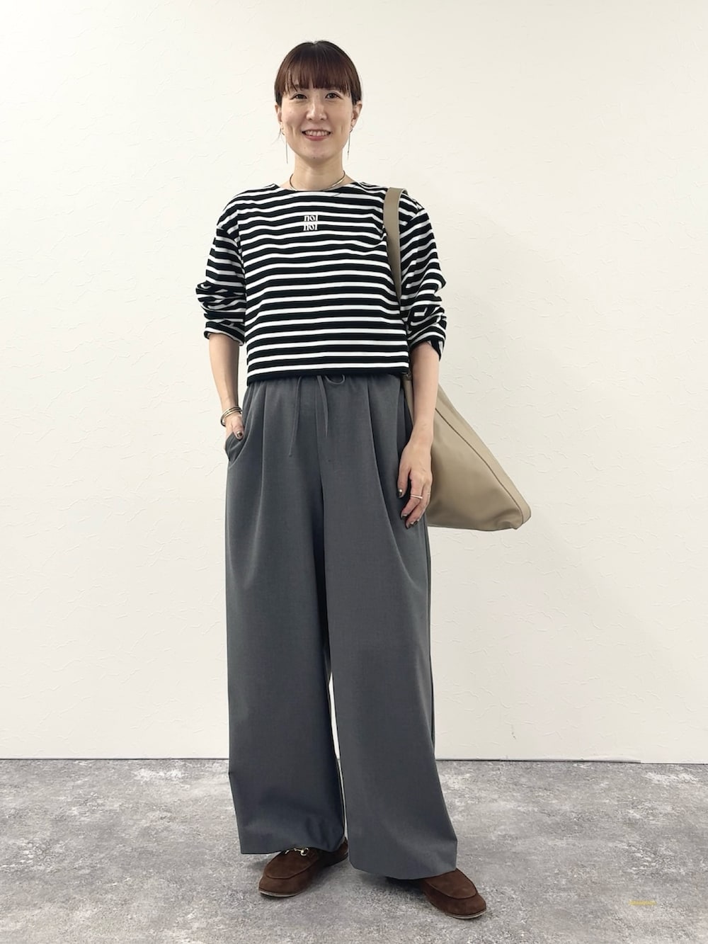 ブラック系のTシャツ/カットソー、ベージュ系のショルダーバッグ、グレー系のその他パンツを着用したレディースの秋コーディネートの2枚目の写真