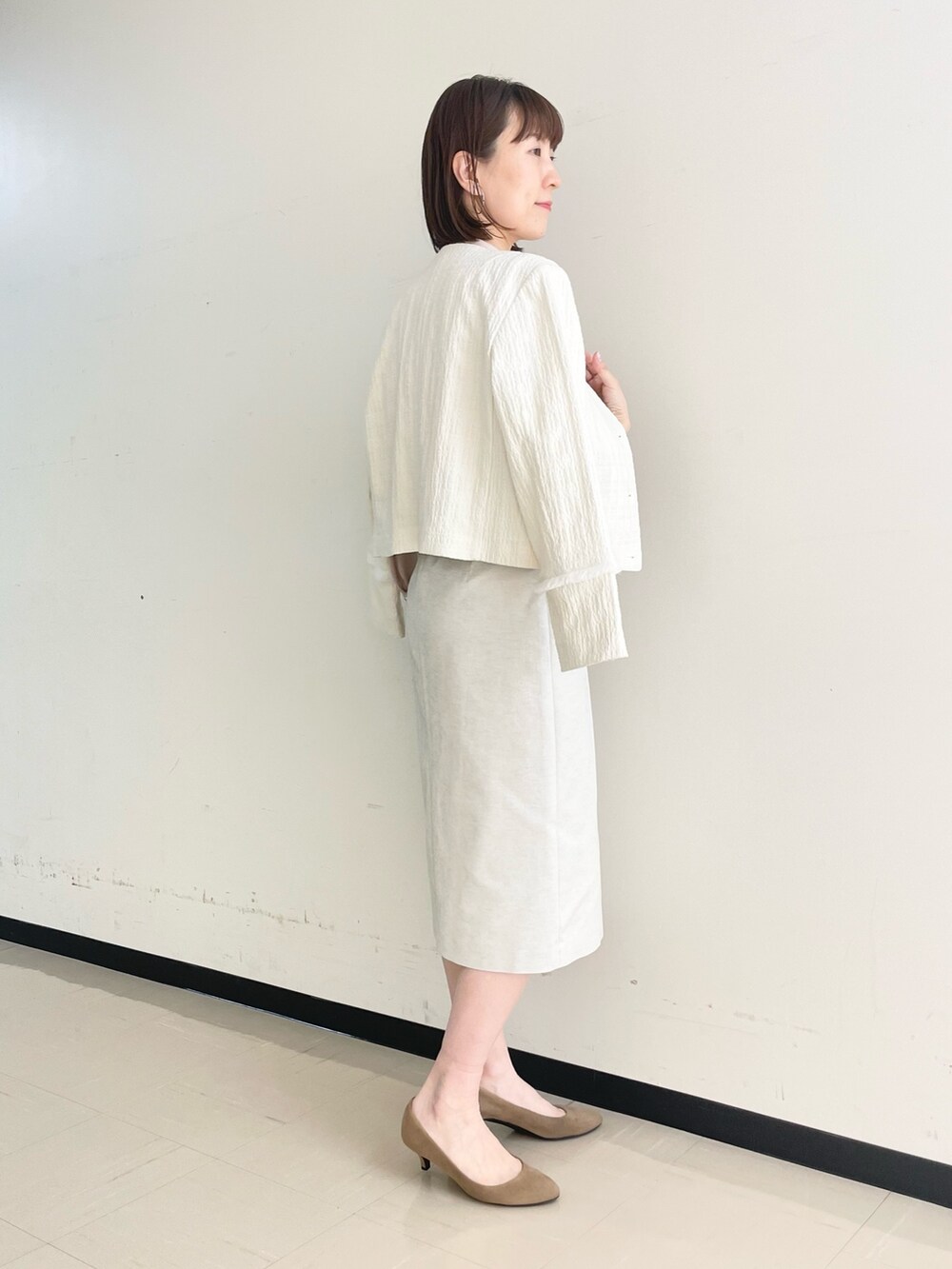 ベージュ系のスカート、ホワイト系のノーカラージャケット、ピンク系のシャツ/ブラウスを着用したレディースの春コーディネートの6枚目の写真