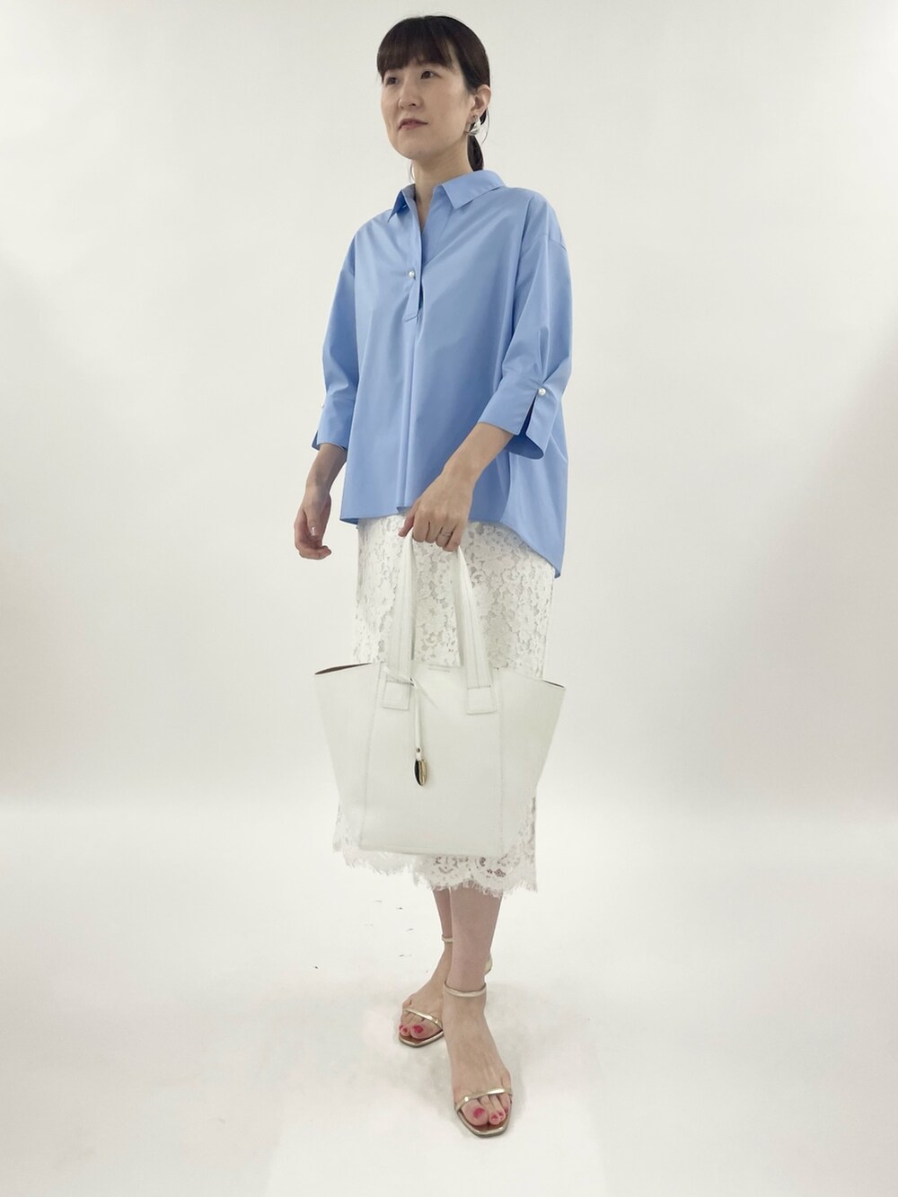 ゴールド系のサンダル、ホワイト系のスカート、ホワイト系のトートバッグを着用したレディースの春コーディネートの5枚目の写真