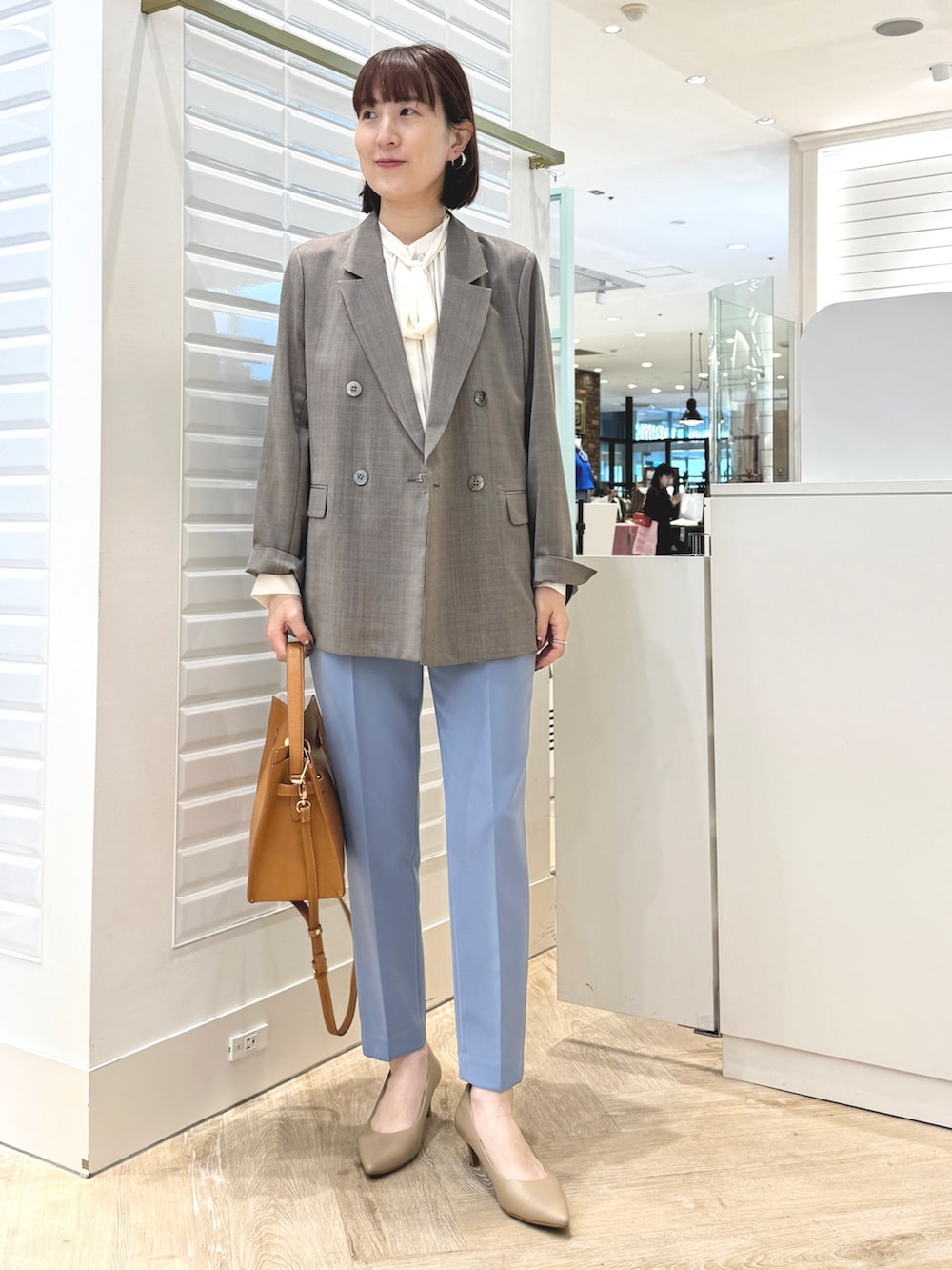 ブルー系のその他パンツ、イエロー系のショルダーバッグ、ブラウン系のテーラードジャケットを着用したレディースの秋コーディネートの2枚目の写真