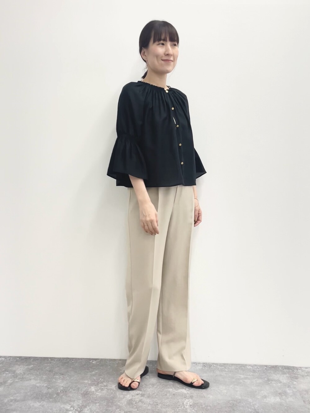 ベージュ系のその他パンツ、ベージュ系のニット/セーター、ブラック系のシャツ/ブラウスを着用したレディースの春コーディネートの2枚目の写真