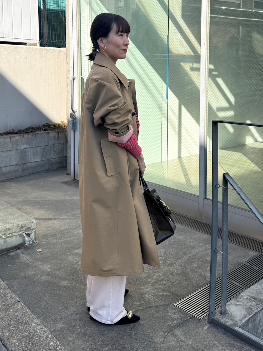 ピンク系のニット/セーター、ベージュ系のダッフルコート、ピンク系のデニムパンツを着用したレディースの冬コーディネートの6枚目の写真