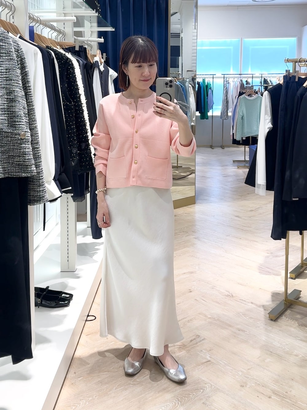 ホワイト系のスカート、ピンク系のカーディガン/ボレロ、ホワイト系のネックレスを着用したレディースの春コーディネートの4枚目の写真