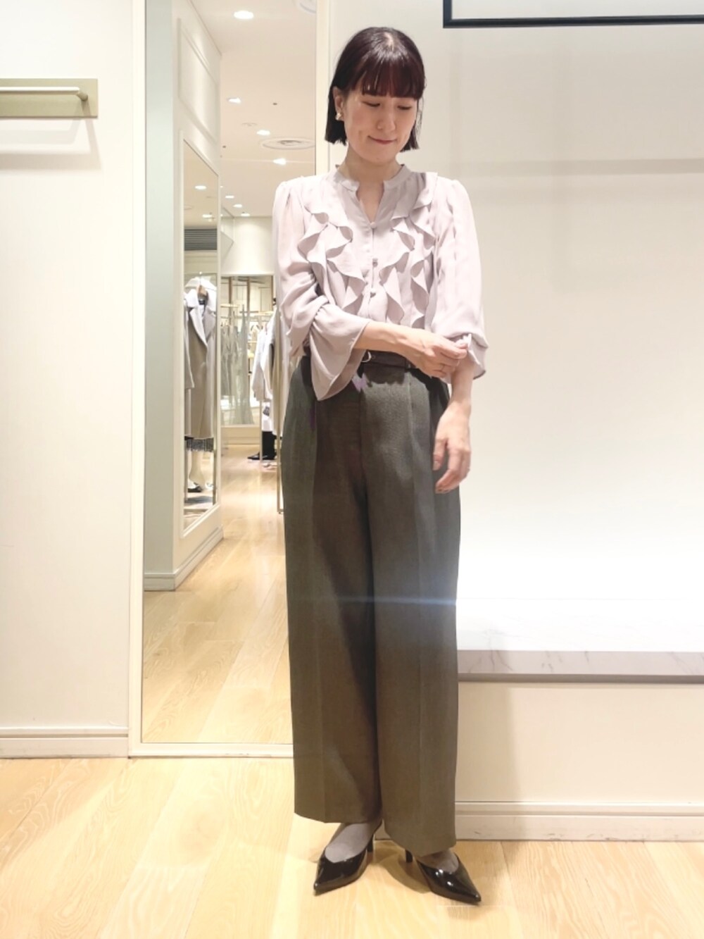 グレー系のその他パンツ、ピンク系のシャツ/ブラウス、ゴールド系のイヤリングを着用したレディースの冬コーディネートの9枚目の写真